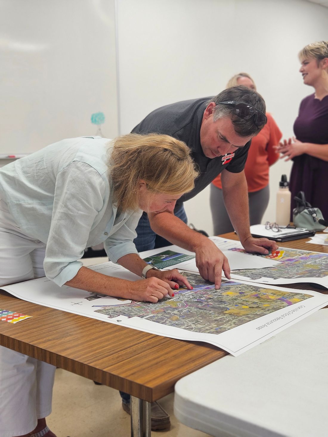 Two residents point to locations on a large Granville Critical Resource Areas map